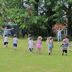 Nursery Children Playing in Field